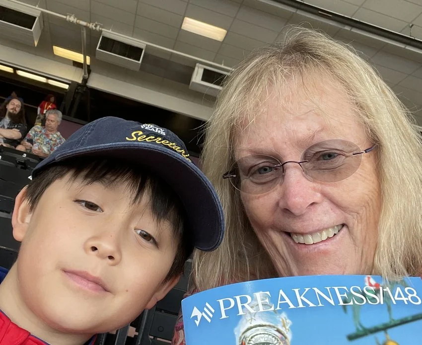 A young fan holding a Preakness program.